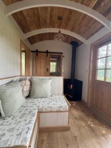 a large bed in a room with a wooden ceiling at Dreamers Hut in Dipton