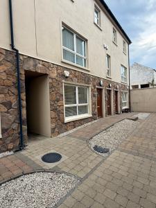 Un edificio de piedra con garaje y un edificio. en Ballycastle, Beachside Apartment, en Ballycastle