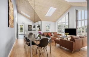 a dining room and living room with a table and chairs at Four-Bedroom Holiday Home In Rudkobing in Spodsbjerg