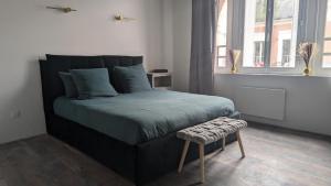 a bedroom with a large bed with a bench next to it at Alcova in Ham