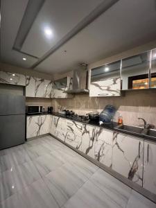 a large kitchen with marble counter tops and stainless steel appliances at Dreamy 2 BHK Escape Near Airport DHA PH 8 in Dargai +15 photos