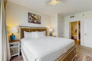 ein Schlafzimmer mit einem großen weißen Bett und zwei Lampen in der Unterkunft Sterling Breeze 2304 in Panama City Beach + 28 Fotos