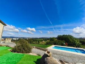 a house with a swimming pool and a green yard at Casa Alamela in Penafiel