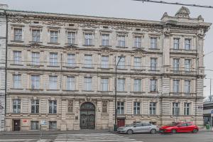 a large stone building with two cars parked in front at Heart of Prague Lodgings 3 in Prague