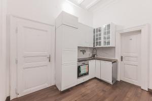 a white kitchen with white cabinets and a sink at Heart of Prague Lodgings 3 in Prague +11 photos