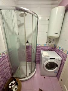 y baño rosa con ducha y lavadora. en Baiona-Mar, gastronomía y cultura, en Baiona 7 fotos más