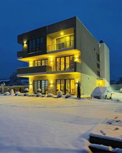 a large building with snow in front of it at Papa Apartments in Berovo