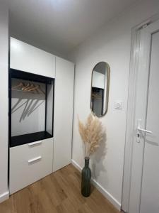 a white room with a vase with flowers in it at Le Studio Chic in Le Portel