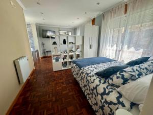 Un dormitorio con una cama con sábanas azules y blancas. en Baiona-Mar, gastronomía y cultura, en Baiona