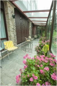 une terrasse avec des tables, des chaises et des fleurs roses dans l'établissement Hotel Ibaiondo, à Olave