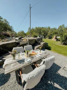 a wooden table with chairs and a meal on a patio at Stonecutter's Cottage In Scenic Lysekil in Lysekil