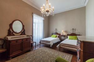 a room with two beds and a mirror and a vanity at Casa da Rua D'água in Ponta Delgada