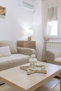 Una sala de estar con una mesa de café con un frasco de vidrio. en Apartman Vukota 2 Pirot, en Pirot