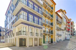 ポルトにあるCardosas Story Apartments by Porto City Hostsの黄色と青の塗装のアパートメントビル