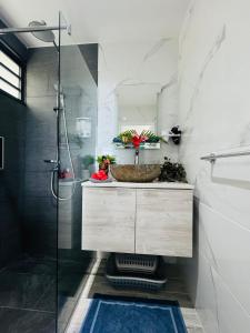 a bathroom with a sink and a shower at Villa Tematahi - maison moderne avec piscine privée in Faaa +23 photos
