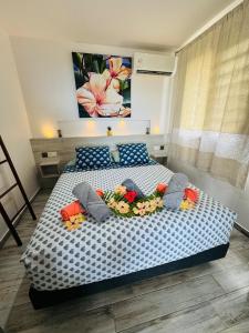 a bedroom with a bed with flowers on it at Villa Tematahi - maison moderne avec piscine privée in Faaa