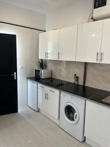 eine Küche mit weißen Schränken und einer Waschmaschine in der Unterkunft Azurian stay in Vallauris