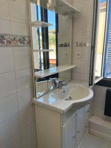 ein Badezimmer mit Waschbecken und Spiegel in der Unterkunft Azurian stay in Vallauris