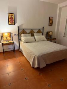 ein Schlafzimmer mit einem großen Bett und Fliesenboden in der Unterkunft Finca Jaralta de Carmen in La Puebla de los Infantes + 15 Fotos