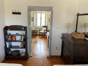 a room with a book shelf and a room with a table at The Seashell House - Chora, Kythera in Kythira