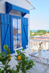 a table and chairs on a balcony with a blue door at Sirena Seaview Apartment - FREE PARKING in Varna City