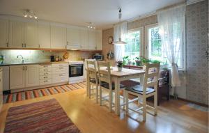 a kitchen with a table and chairs in a room at Villa Utsikten in Kristinehamn