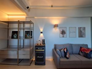 a living room with a couch and a shelf at Helbor Stay Santos Pompéia Gonzaga - Varanda vista mar in Santos