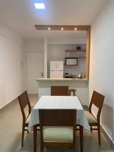 a dining room with a table and chairs and a kitchen at Apto Novo no Centro de Serra Negra com Garagem in Serra Negra