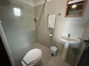 a small bathroom with a toilet and a sink at Pousada vale verde bungalows - Praia do Rosa in Praia do Rosa