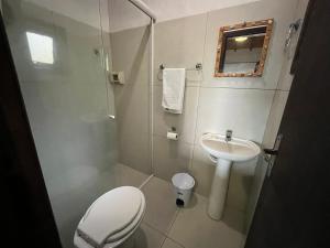 a small bathroom with a toilet and a sink at Pousada vale verde bungalows - Praia do Rosa in Praia do Rosa +97 photos