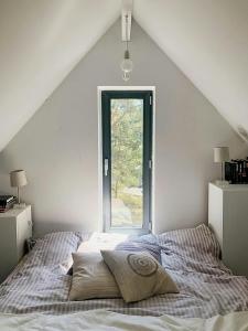 Un dormitorio blanco con una cama con ventana. en Sea View Paradise Secret Oasis At The Baltic Sea, en Yngsjö