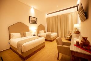 a hotel room with two beds and a living room at Hotel La Finca por Zotoluca in Apan
