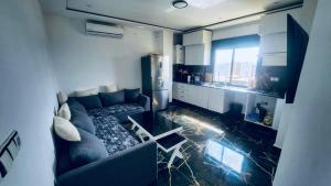 un salon avec un canapé et une cuisine dans l'établissement terrasse privée vue mer, à Oran