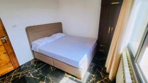 un petit lit dans une chambre avec une fenêtre dans l'établissement terrasse privée vue mer, à Oran
