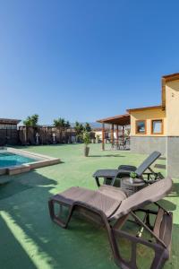 a group of chairs sitting on a patio next to a pool at VALTISYA POOL AND AIRPORT in Telde