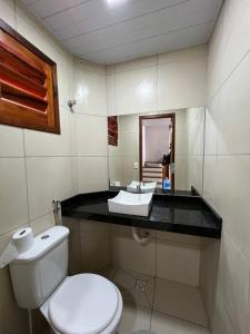 a bathroom with a white toilet and a sink at Chalé Sossego Serrano in Mulungu +16 photos