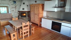 a kitchen with a wooden table and a kitchen with a fireplace at Locazione turistica Lou Bindel in Sampeyre