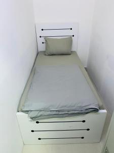 a bed in a white room with a pillow on it at cozy pavilion in Dubai