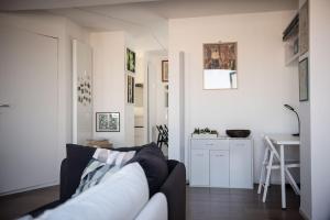 a white living room with a couch and a table at Penthouse with terrace Cavour 26 in Udine