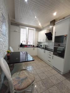 a kitchen with white cabinets and a table and chairs at Villa Varzob ll in Warsaw