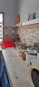 uma cozinha com um balcão com panelas e frigideiras em Fare de l'escale Em Faaa