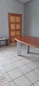 uma mesa de madeira num piso de azulejo com uma porta em Fare de l'escale Em Faaa mais 1 fotografia