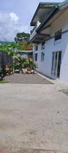 uma casa branca com plantas na frente em Fare de l'escale Em Faaa