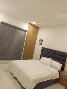 a bedroom with a large bed with white sheets and pillows at Golf news in Benin City +18 photos