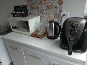 a kitchen counter with a microwave and a toaster at Casa Ampla em Boituva-SP in Boituva