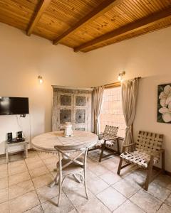 een eetkamer met een tafel, stoelen en een tv bij Cabaña en el casco urbano de Subachoque in Subachoque