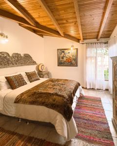 een slaapkamer met een groot bed en een houten plafond bij Cabaña en el casco urbano de Subachoque in Subachoque