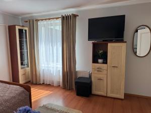 a living room with a flat screen tv on a dresser at Domek M5 w centrum Wiela in Wiele