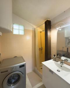 a bathroom with a washing machine and a sink at Évasion en bord de mer - T2 au coeur des calanques in Ensuès-la-Redonne