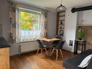 a living room with a table and chairs and a window at Domek M5 w centrum Wiela in Wiele
